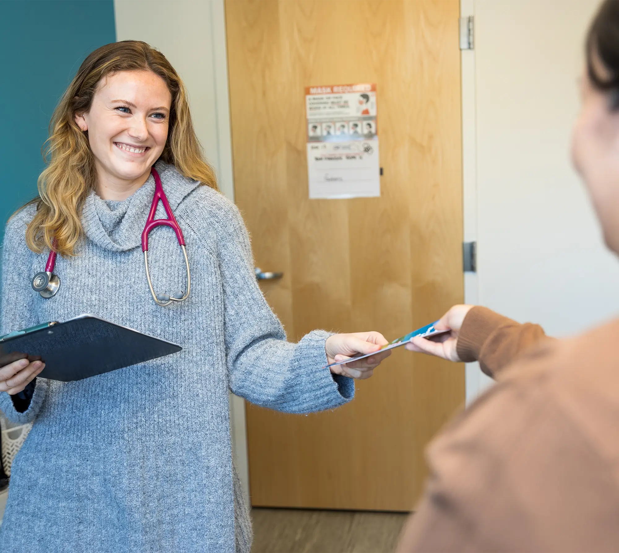 A female doctor handing a patient a brochure